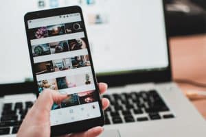 woman holding smartphone with photos on screen